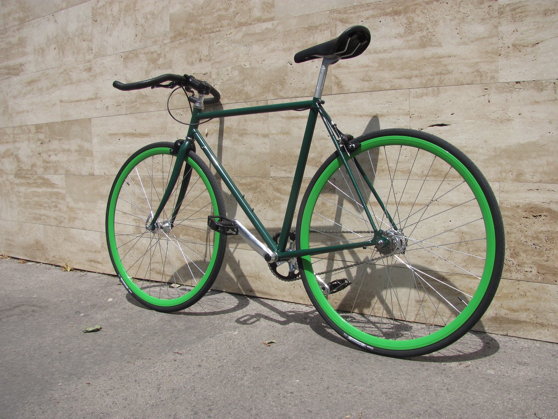 Zielony rower typu "Ostre Koło" z kierownicą szosową.